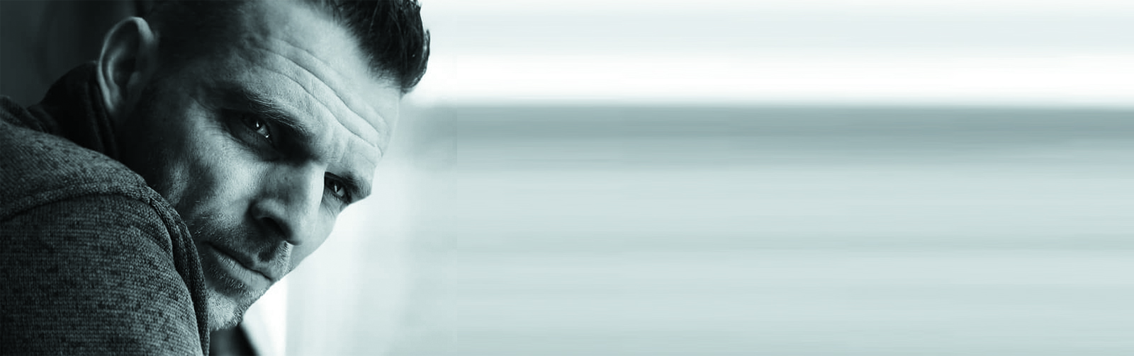 Close-up of a man looking thoughtfully out of a window